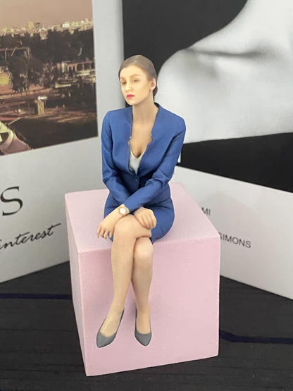 Custom seated portrait figurine displayed on a pink block